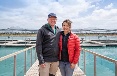 Two people standing in front of Murray cod farm
